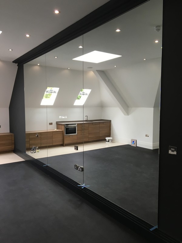 Frameless glass partition in loft conversion by Holborn glaziers